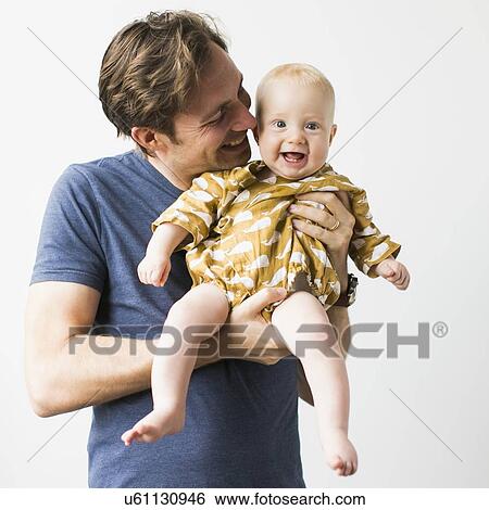 Stock Photograph - Studio portrait of father with baby son (2-5 months). Fotosearch