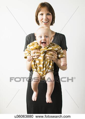 Stock Image - Studio portrait of mother with baby son (2-5 months). Fotosearch