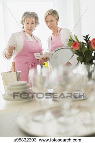 Two mature women preparing catering View Large Photo Image Stock Image - Two mature women preparing catering. Fotosearch