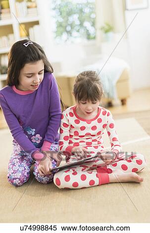 Two sisters (4-5, 8-9) using tablet pc View Large Photo Image Stock Photography - Two sisters (4-5, 8-9) using tablet pc. Fotosearch