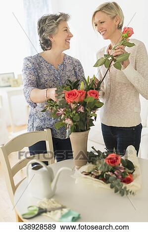 Stock Photo - Two women arranging bouquet. Fotosearch