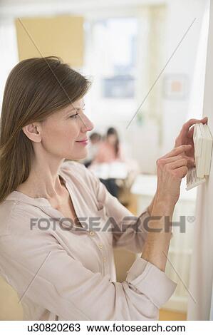 Woman adjusting house alarm View Large Photo Image Stock Image - Woman adjusting house alarm. Fotosearch