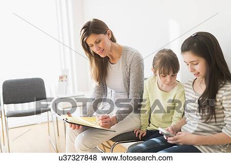 Woman and girls (4-5, 8-9) in waiting room View Large Photo Image Stock Photo - Woman and girls (4-5, 8-9) in waiting room. Fotosearch