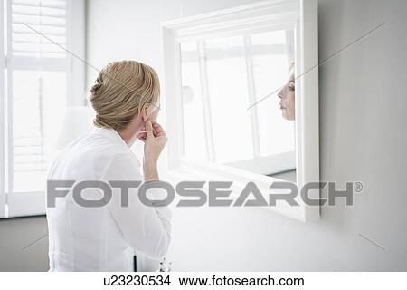 Woman applying make-up View Large Photo Image Picture - Woman applying make-up. Fotosearch