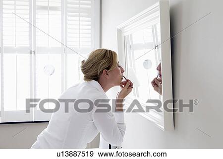 Woman applying make-up View Large Photo Image Stock Photo - Woman applying make-up. Fotosearch