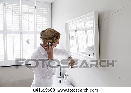 Woman checking time and talking on mobile View Large Photo Image Stock Photo - Woman checking time and talking on mobile. Fotosearch