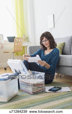 Stock Photo - Woman doing paperwork at home. Fotosearch