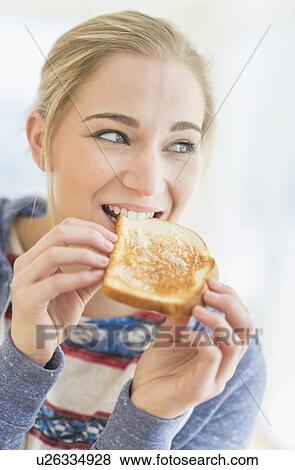 Woman eating toast View Large Photo Image Stock Photo - Woman eating toast. Fotosearch