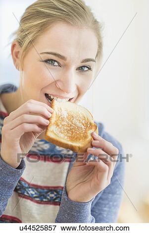 Woman eating toast View Large Photo Image Stock Photo - Woman eating toast. Fotosearch