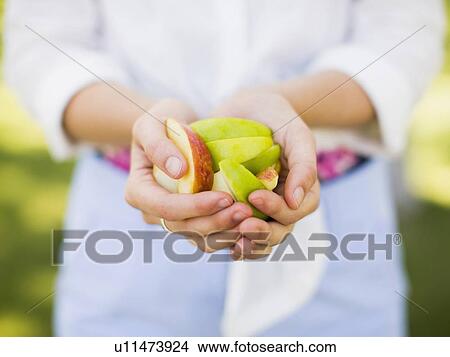 Picture - Woman holding sliced apple. Fotosearch