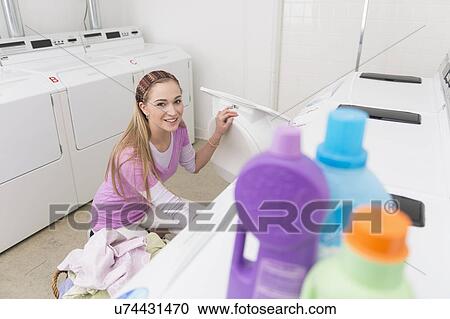 Woman loading laundry into washing machine View Large Photo Image Stock Image - Woman loading laundry into washing machine. Fotosearch