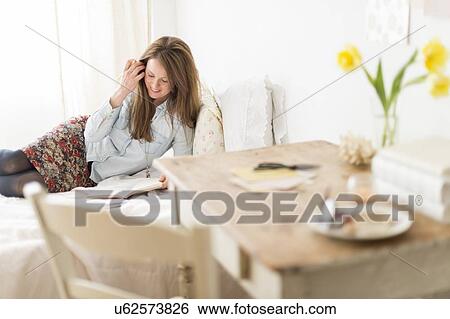 Woman lying on bed and writing diary View Large Photo Image Stock Photograph - Woman lying on bed and writing diary. Fotosearch