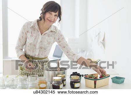 Woman making preserves in kitchen View Large Photo Image Stock Photography - Woman making preserves in kitchen. Fotosearch