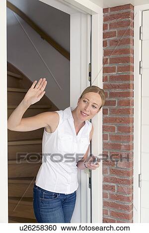 Woman opening door and waving View Large Photo Image Stock Image - Woman opening door and waving. Fotosearch