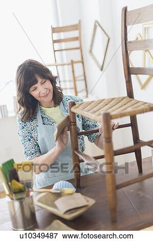 Stock Photo - Woman restoring antique furniture. Fotosearch