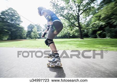 Woman roller skating in park View Large Photo Image Stock Image - Woman roller skating in park. Fotosearch