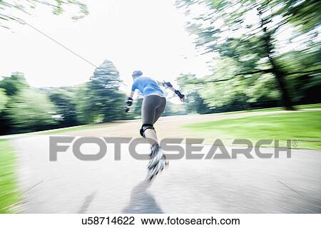Woman roller skating in park View Large Photo Image Stock Image - Woman roller skating in park. Fotosearch