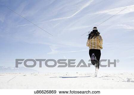 Stock Photo - Woman running on snow. Fotosearch