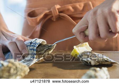 Stock Photo - Woman shucking oysters. Fotosearch