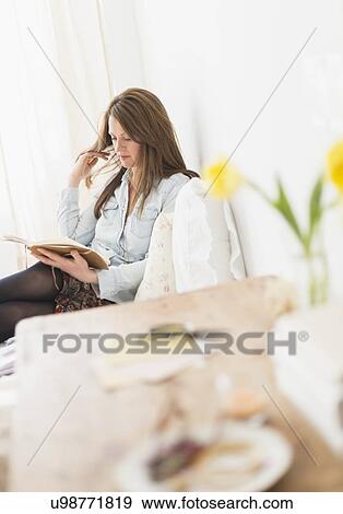 Woman sitting on bed and reading diary View Large Photo Image Stock Photo - Woman sitting on bed and reading diary. Fotosearch