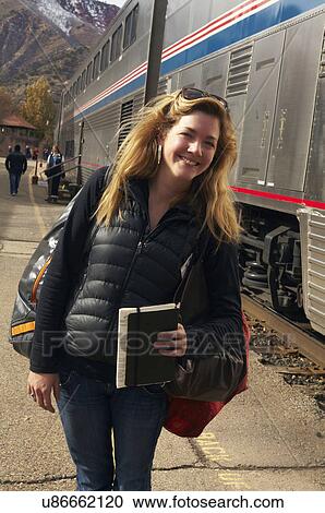 Woman smiling at train station View Large Photo Image Stock Image - Woman smiling at train station. Fotosearch