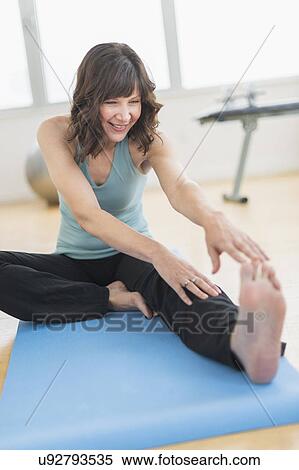 Woman stretching in gym View Large Photo Image Stock Photography - Woman stretching in gym. Fotosearch