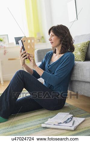 Picture - Woman using tablet pc at home. Fotosearch