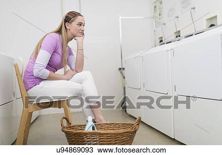 Woman waiting in laundromat View Large Photo Image Stock Image - Woman waiting in laundromat. Fotosearch