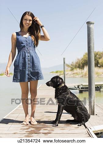 Woman with dog standing on jetty View Large Photo Image Picture - Woman with dog standing on jetty. Fotosearch