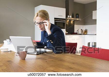 Woman working in dining room View Large Photo Image Stock Photo - Woman working in dining room. Fotosearch