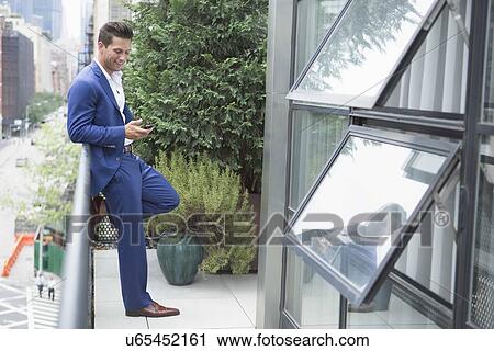 Young businessman relaxing when text messaging View Large Photo Image Stock Image - Young businessman relaxing when text messaging. Fotosearch
