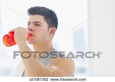 Stock Image - Young man drinking sports drink. Fotosearch