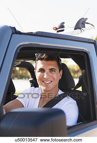 Young man driving car View Large Photo Image Stock Photo - Young man driving car. Fotosearch