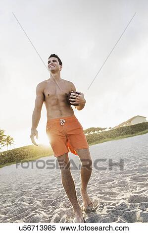 Young man playing football on beach View Large Photo Image Stock Photography - Young man playing football on beach. Fotosearch