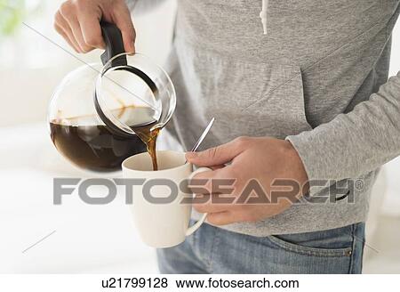 Young man pouring coffee View Large Photo Image Stock Photo - Young man pouring coffee. Fotosearch