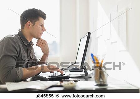 Stock Photograph - Young man using computer. Fotosearch