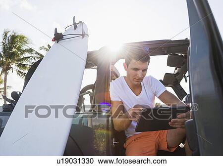 Young man using digital tablet View Large Photo Image Stock Image - Young man using digital tablet. Fotosearch
