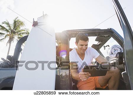 Young man using digital tablet View Large Photo Image Stock Photo - Young man using digital tablet. Fotosearch