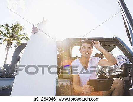 Stock Photograph - Young man using digital tablet. Fotosearch