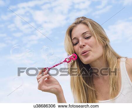 Young woman blowing bubbles View Large Photo Image Stock Photograph - Young woman blowing bubbles. Fotosearch