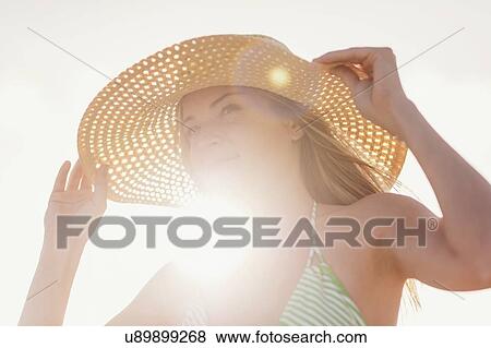 Stock Photo - Young woman in sun hat on beach. Fotosearch