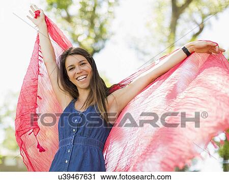 Young woman playing with scarf in park View Large Photo Image Stock Image - Young woman playing with scarf in park. Fotosearch