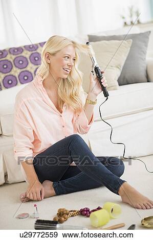 Young woman using curling tongs View Large Photo Image Stock Photo - Young woman using curling tongs. Fotosearch