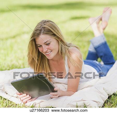 Young woman using digital tablet View Large Photo Image Stock Image - Young woman using digital tablet. Fotosearch