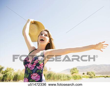 Young woman with sun hat on beach View Large Photo Image Stock Photograph - Young woman with sun hat on beach. Fotosearch