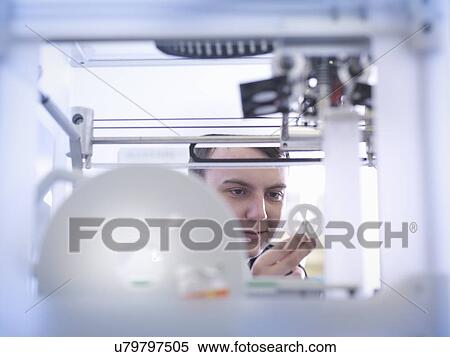 Stock Photography - Apprentice with 3D printed part, close up. Fotosearch