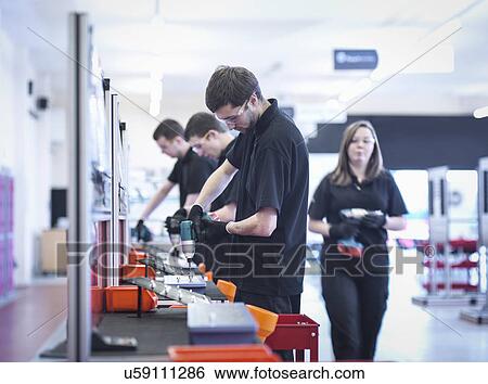 Apprentices working on training production line View Large Photo Image Stock Photograph - Apprentices working on training production line. Fotosearch