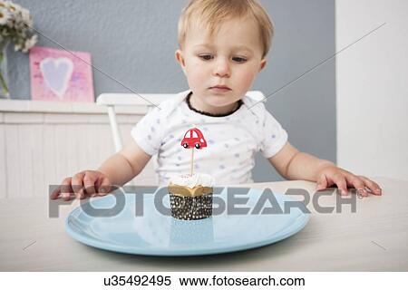 Baby boy looking at cupcake View Large Photo Image Stock Photography - Baby boy looking at cupcake. Fotosearch