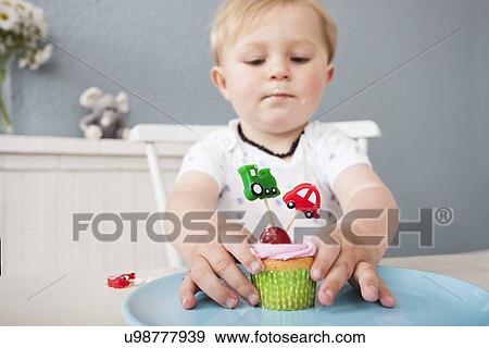 Baby boy playing with cupcake View Large Photo Image Stock Photo - Baby boy playing with cupcake. Fotosearch
