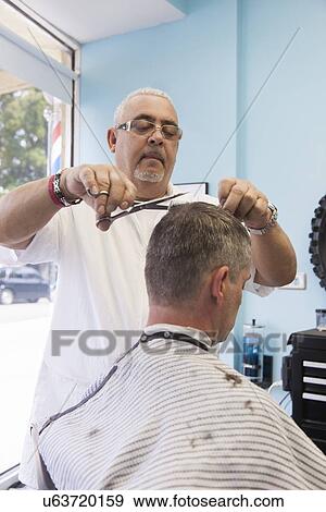 Barber cutting man's hair View Large Photo Image Stock Photo - Barber cutting man's hair. Fotosearch